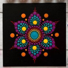 a colorful painting on a black background with orange, blue and yellow circles in the center