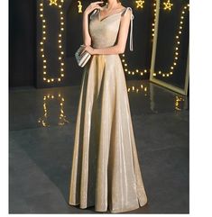 Gold V-neck Evening Dress With Sweep Train, Elegant Gold V-neck Evening Dress, Gold V-neck Evening Dress For Gala, Gold Sleeveless Holiday Evening Dress, Champagne Evening Dress With Sweep Train For Gala, Elegant Sleeveless Gold Ball Gown, Gold Sleeveless Ball Gown For Party, Gold Evening Dress For Holiday Gala, Champagne Evening Dress With Sweep Train