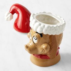 a ceramic cup with a red nose and santa claus hat on it's head