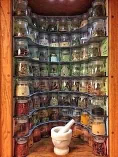 a wooden shelf filled with lots of jars and spices