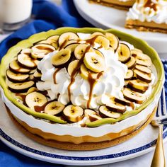 a banana cream pie with whipped cream and sliced bananas in the middle on a plate