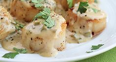 a white plate topped with meat covered in sauce and garnished with parsley