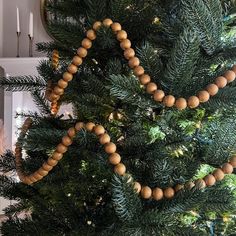 a close up of a christmas tree with beads on it's branches and a mirror in the background