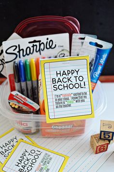 a plastic container filled with school supplies on top of a table