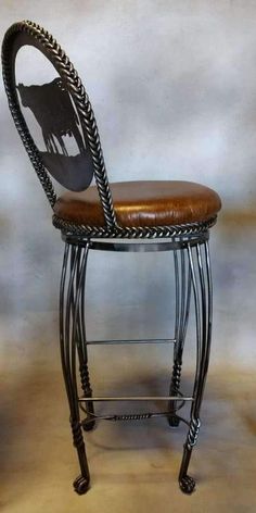 a metal stool with a brown leather seat