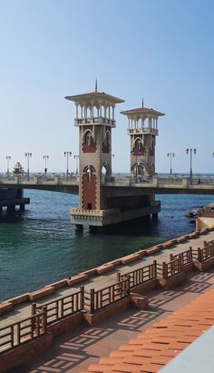 two large clock towers sitting on top of a pier