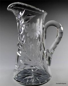 a clear glass pitcher with flowers on it