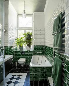 a bathroom with green and white tiles on the walls