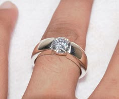 a woman's hand with a diamond ring on it