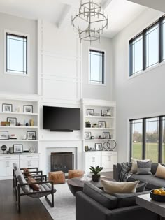 a living room filled with lots of furniture and a flat screen tv mounted above the fireplace