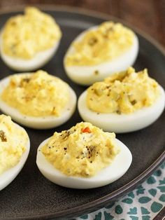 deviled eggs are arranged on a black plate