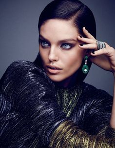 a woman with blue eyes is posing for a magazine cover photo shoot, holding her hand on her head