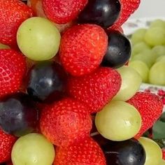 a bunch of grapes and strawberries are stacked on top of each other