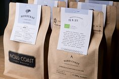 three brown paper bags sitting on top of a wooden table