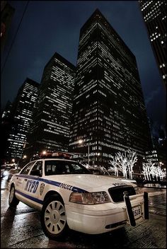 a police car parked in front of a tall building with lights on it's sides