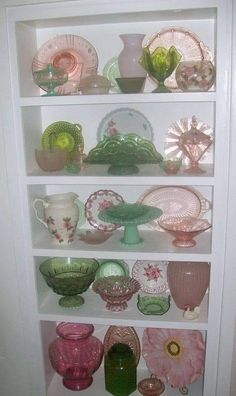 the shelves are filled with glass dishes and vases