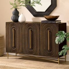 a sideboard with two vases and a mirror on the wall