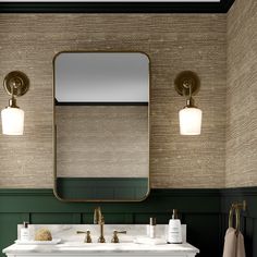 a bathroom with two sinks and a large mirror over it's counter top, along with gold faucets