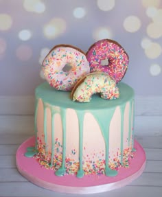 two donuts on top of a cake with sprinkles