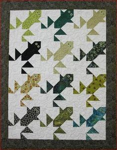 a quilt made to look like an arrow with many different colors and shapes on it