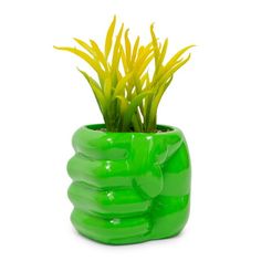 a green planter with yellow flowers in it on a white background and no people around