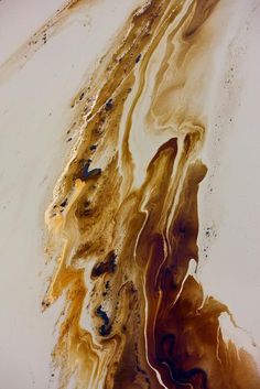 an abstract painting with brown, yellow and black colors on it's surface is shown