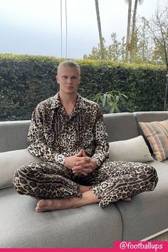 a man sitting on top of a couch wearing leopard print pajamas