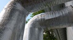 two large metal pipes with trees in the background