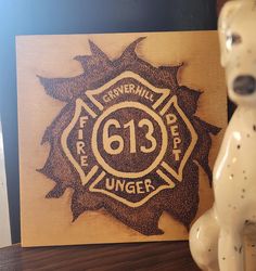 a dog statue sitting next to a wooden plaque with the number 613 on it