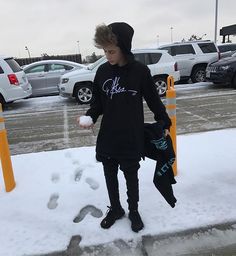 a young man standing in the snow with his foot prints