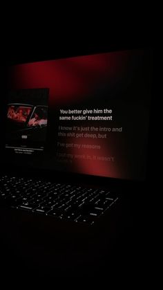 a laptop computer sitting on top of a black table next to a red screen with the words you better give him the chance