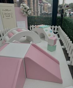 a pink and white bed sitting on top of a table