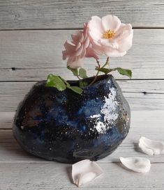 a blue vase with two pink flowers in it