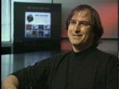 a man with glasses sitting in front of a tv