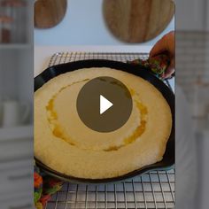 a pancake is being cooked on a wire rack with a video screen showing how to make it