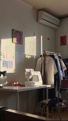 a sewing machine sitting on top of a white table next to a desk and chair