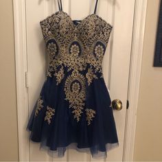 Navy Strapless Dress With Gold Embroidery. Lace Up/Corset Back. New With Tags. Such A Beautiful Dress Pictures Don’t Do It Justice. New With Tags. Built In Padding In Chest. Floral Embroidered Dresses For Homecoming And Prom, Homecoming Dresses With Sweetheart Neckline And Floral Embroidery, Blue Prom Dress With Floral Embroidery, Fitted Dress With Intricate Embroidery For Prom, Blue Floral Embroidered Prom Dress, Fitted Embroidered Dresses For Prom Season, Royal Blue Mini Dress For Homecoming, Elegant Blue Embroidered Party Dress, Elegant Embroidered Dress For Homecoming