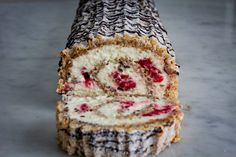 a piece of cake sitting on top of a counter covered in frosting and raspberries