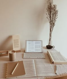 an open book sitting on top of a desk next to a laptop computer and keyboard