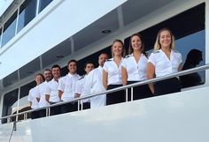 a group of people standing on the side of a boat in front of some windows