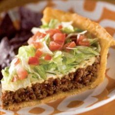 a piece of pie with lettuce and tomatoes on it sitting on a plate