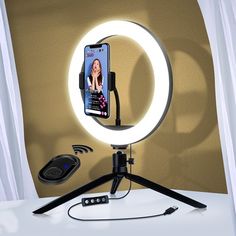 a cell phone sitting on top of a tripod with a light in front of it