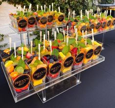 an assortment of fruit is displayed in plastic trays on a black tablecloth covered table