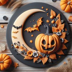 a cake decorated to look like a halloween pumpkin on top of a moon with bats and stars