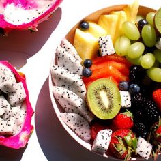 a fruit salad with kiwis, grapes, and strawberries in a bowl