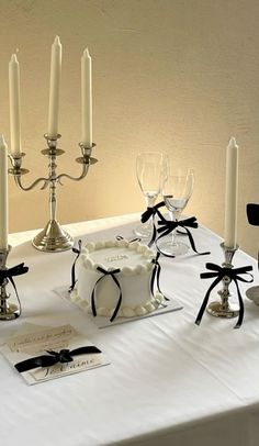 a table topped with a cake covered in white frosting next to candles and napkins