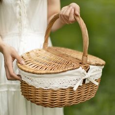 a woman holding a wicker basket in her hands