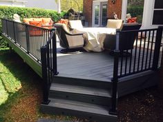 a deck with black railing and chairs on it