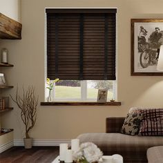 a living room filled with furniture and a window covered in wooden slatted blinds