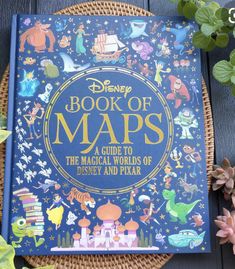 the book of maps is sitting next to some plants